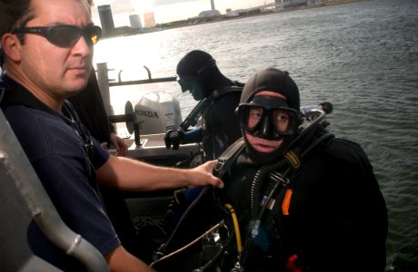 US Navy 051119-N-9851B-011 U.S. Navy Gunner's Mate 1st Class Benjamin Rudolph supports Chief Sonar Technician Isaac Callicrate, as they move to a new position in Tokyo Bay