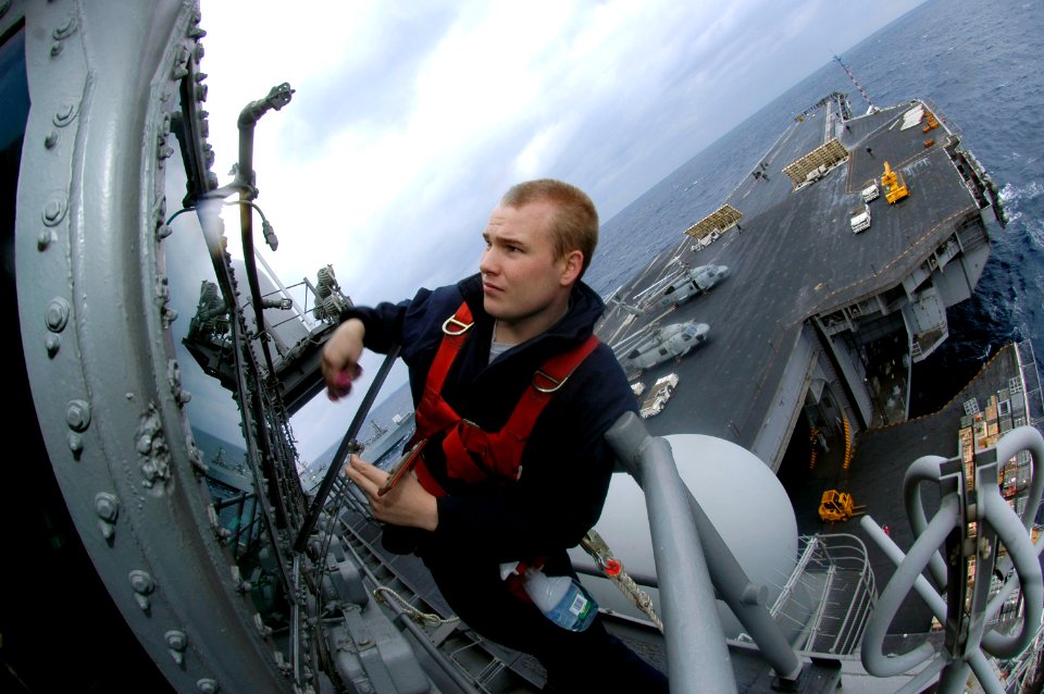 US Navy 051208-N-9389D-198 Quartermaster Seaman Edward Lennerville, cleans the viewing ports during a vertical replenishment (VERTREP) aboard the conventionally powered aircraft carrier USS Kitty Hawk's (CV 63)