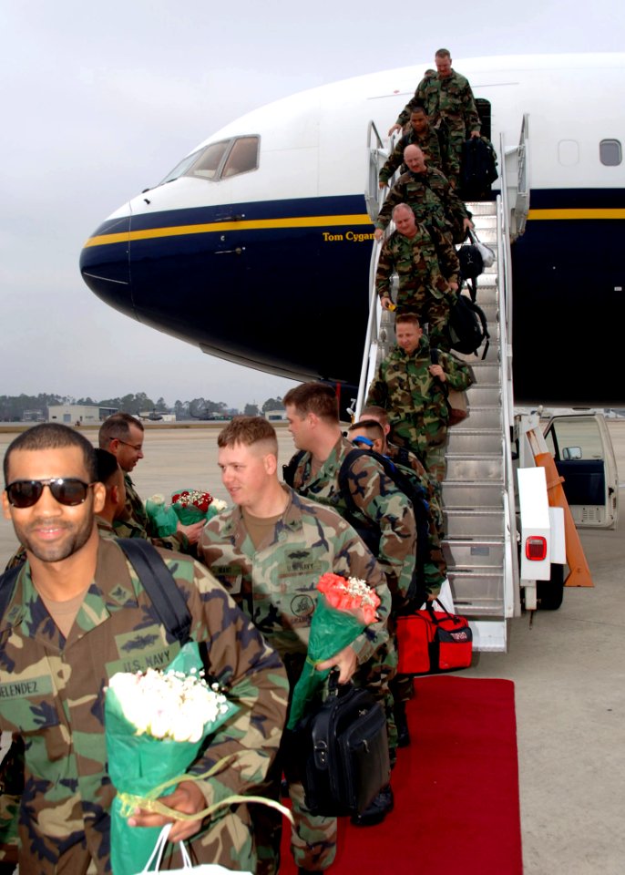 US Navy 051205-N-1132S-018 New fathers assigned to Naval Mobile Construction Battalion Seven Four (NMCB-74) receives flowers as they return home from a six-month deployment to Okinawa, Japan
