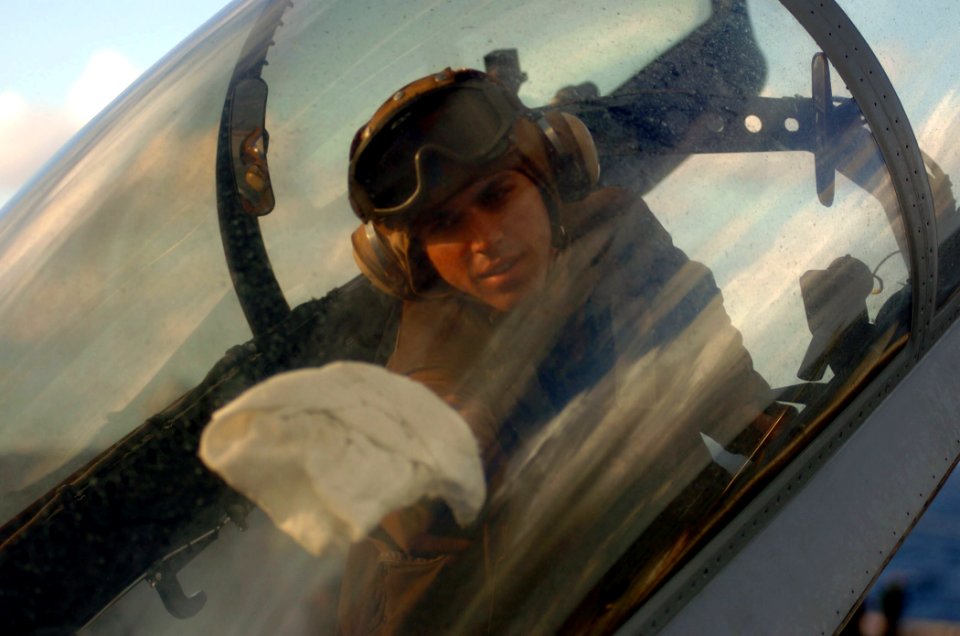 US Navy 051206-N-3488C-003 A plane captain cleans the canopy of one of his squadron's F-A-18F Super Hornets prior to flight operations
