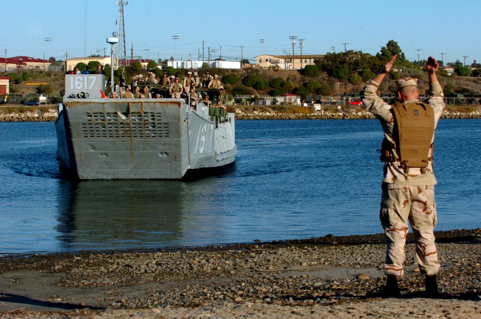 US Navy 051205-N-9866B-283 U.S. Navy Construction Mechanic 3rd Class Erik Berggreng, assigned to Beach Master Unit, guides-in a Landing Craft, Utility, assigned to Assault Craft Unit One (ACU-1), onto the landing area