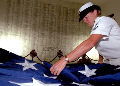 US Navy 051206-N-3019M-005 Machinery Repairman 1st Class Michelle Young folds the National Ensign in the shrine room of the USS Arizona Memorial
