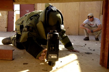 US Navy 051218-F-7234P-061 U.S. Navy Chief Petty Officer Zach Holzhausen watches Waleed Humayan Ahmed, a Yemen Explosive Ordinance Disposal (EOD) team member, place an x-ray machine near an Improvised Explosive Device (IED) dur