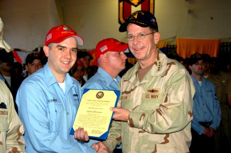 US Navy 060109-N-0000X-002 Chief of Naval Operations, Adm. Mike Mullen, pose for a photo after reenlisting eight Sailors aboard the amphibious transport dock ship USS Austin (LPD 4)