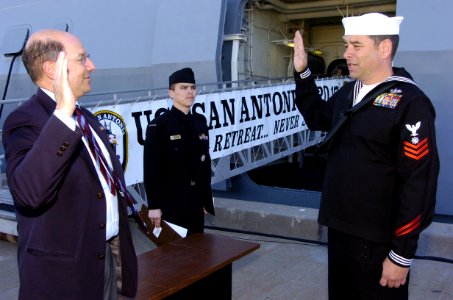US Navy 060113-N-2568S-100 Secretary of the Navy, Dr. Donald C. Winter administers the oath of reenlistment to Quartermaster 1st Class Thomas E. Dowling on the pier
