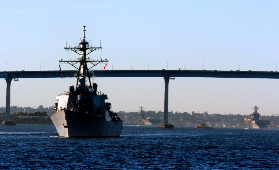 US Navy 051118-N-9866B-225 The guided missile destroyer USS Milius (DDG 69), foreground, and the amphibious assault ship USS Peleliu (LHA 5) sail under the Coronado Bridge