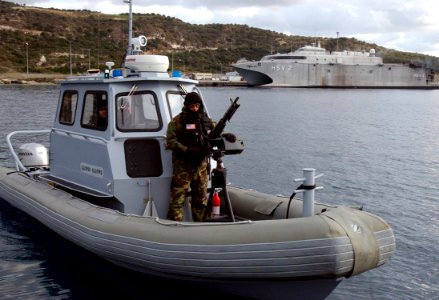 US Navy 060112-N-0780F-006 A Sailor assigned to a harbor patrol unit at the U.S. Naval Support Activity Souda Bay's Security Department mans an M60 7.62 caliber machine gun photo