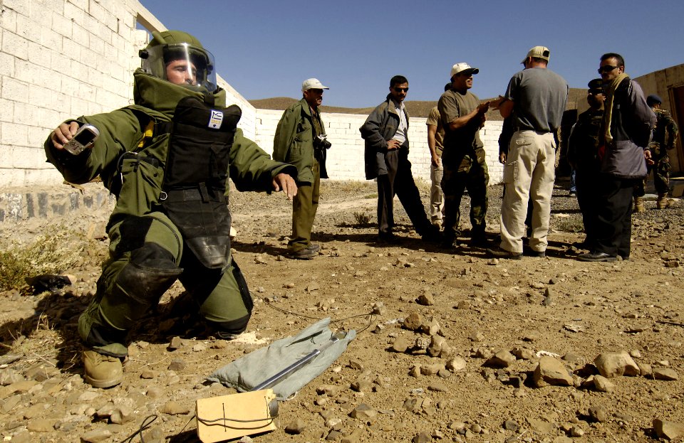US Navy 051214-F-7234P-064 Yemen Explosive Ordinance Disposal (EOD) team members watch, U.S. Navy Petty Officer 2nd Class Frank Fazalore positions a device that will destroy a simulated Improvised Explosive Device (IED)