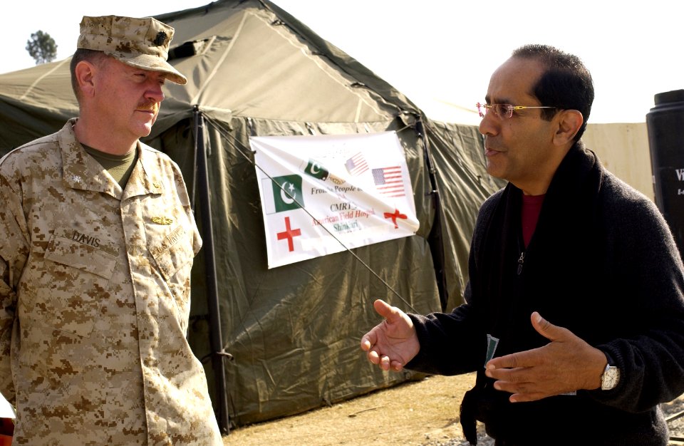 US Navy 051219-F-2729L-005 Advisory Board to U.S. Secretary of Defense member, Dr. Ikram Khan, speaks to Chief of Professional Services for Combined Medical Relief Team Three, Cmdr. Tom Davis at the hospital in Shinkiari