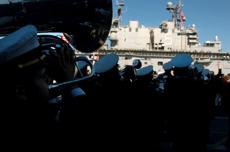 US Navy 051221-N-9866B-139 U.S. Naval Academy Midshipmen Band perform outside the decommissioned aircraft carrier USS Midway (CV 41) in front of the amphibious assault ship USS Peleliu (LHA 5)
