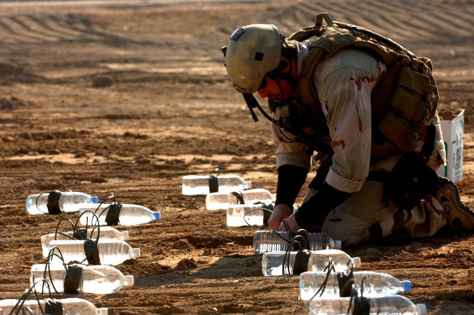 US Navy 060105-A-3283V-010 Aviation Ordnanceman 2nd Class Michael Piccone links explosives together for a test detonation at a range in Ad Diwaniyah, Iraq