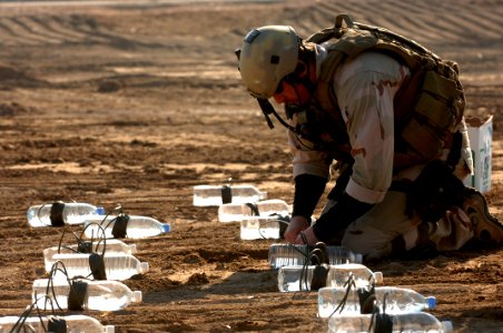 US Navy 060105-A-3283V-010 Aviation Ordnanceman 2nd Class Michael Piccone links explosives together for a test detonation at a range in Ad Diwaniyah, Iraq