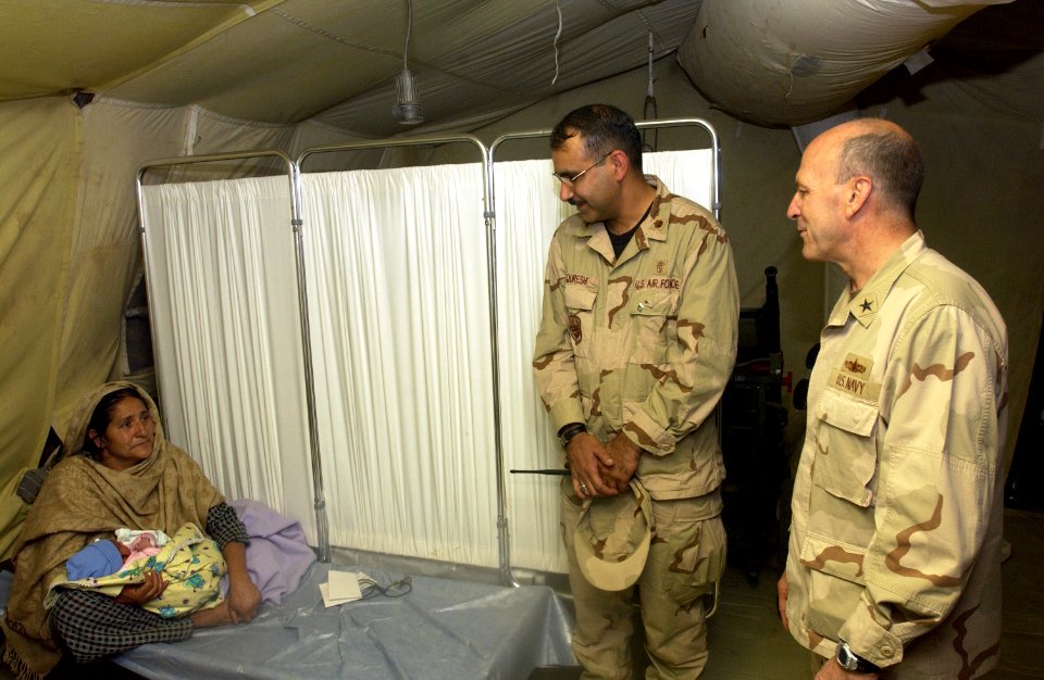 US Navy 051124-F-9927R-003 U.S. Navy Rear Adm. Mike Lefever, right, and Air Force translator Maj. Qureshi talk with a Pakistani grandmother holding her newborn granddaughter