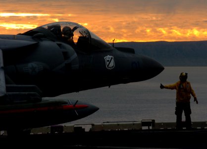US Navy 051210-N-9866B-056 An AV-8B Harrier is directed to move forward after landing on the flight deck of the amphibious assault ship USS Peleliu (LHA 5)