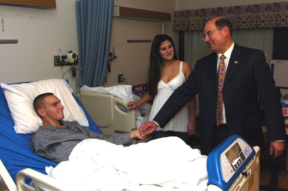 US Navy 060104-N-2568S-001 Secretary of the Navy, the Honorable Dr. Donald Winter meets with Lance Cpl. Joseph Grady and his wife during a visit to see the wounded Sailors and Marines at National Naval Medical Center