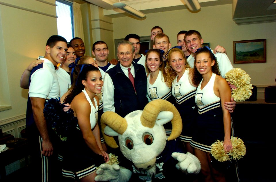 US Navy 051130-N-2568S-004 Secretary of Defense Donald Rumsfeld poses for a photograph with the U.S. Naval Academy cheerleader squad during a Pep-Rally