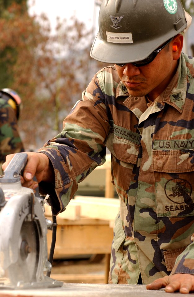 US Navy 060120-F-4462M-069 A U.S. Navy Seabee assigned to Naval Mobile Construction Battalion Four (NMCB-4)) help to build a temporary school in the mountains near Muzaffarabad, Pakistan