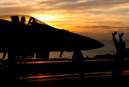 US Navy 051212-N-7130B-063 An F-A-18E Super Hornet is directed into launch position by an aircraft director on the flight deck of the Nimitz-class aircraft carrier USS Ronald Reagan (CVN 76)