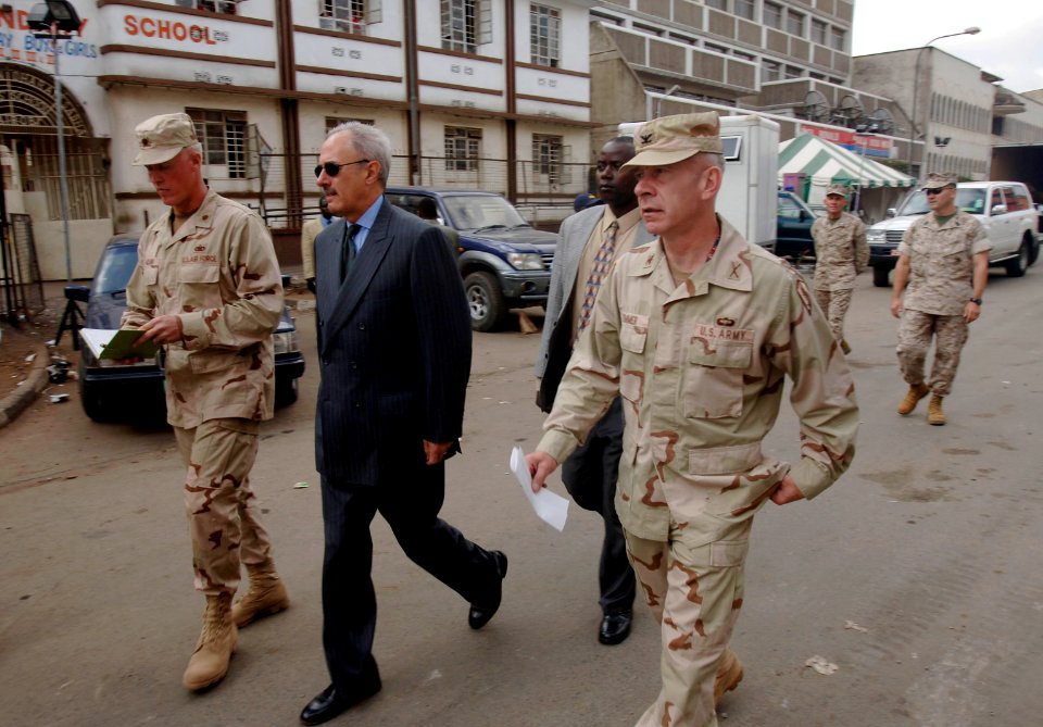 US Navy 060125-F-2902B-073 U.S. Ambassador to Kenya, William Bellamy, center, is escorted by U.S. military personnel to view and discuss rescue and recovery efforts following a building collapse on Nairobi's Ronald Ngala Street