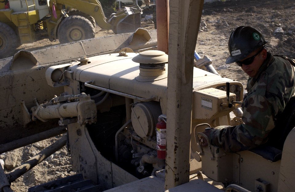 US Navy 060106-F-2729L-032 U.S. Navy Petty Officer 2nd Class Antonio Beltran, assigned to Naval Mobile Construction Battalion Four (NMCB-4), clears debris