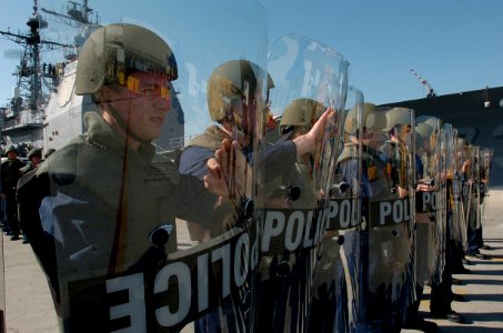 US Navy 060111-N-9866B-009 A riot control team consisting of duty section Sailors assigned to the amphibious assault ship USS Peleliu (LHA 5) braces for a simulated attack