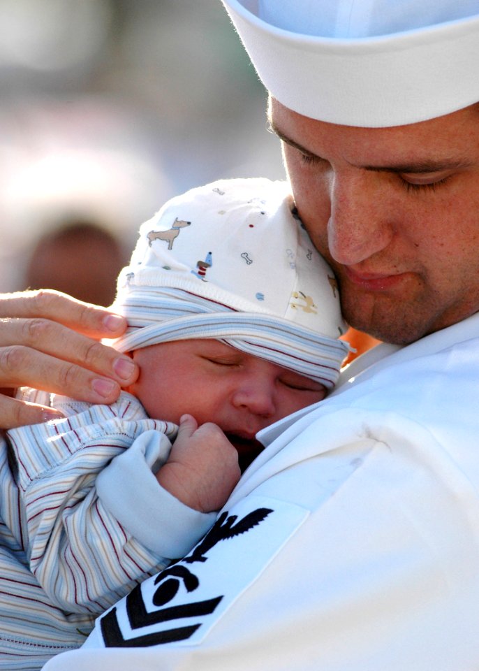 US Navy 060109-N-3019M-007 Interior Communications Electrician 2nd Class Josh Stoneman, assigned to the guided missile cruiser USS Chosin (CG 65), embraces his son