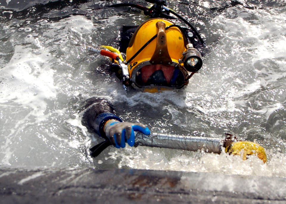 US Navy 051206-N-0879R-005 A U.S. Navy diver uses a scrubber to clean the hull of the Los Angeles-class fast attack submarine USS Key West (SSN 722)