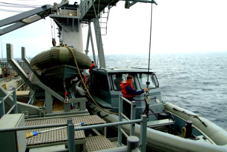 US Navy 051211-N-4772B-027 Seaman Willaim Schroeder mans the bowhook on one of the ship's new Rigid Hull Inflatable Boats (RHIB) on the boat davit aboard the amphibious landing dock USS Harpers Ferry (LSD 49)