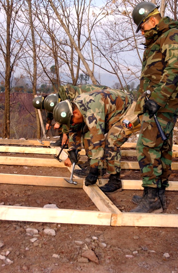 US Navy 060120-F-4462M-021 U.S. Navy Seabees assigned to Naval Mobile Construction Battalion Four (NMCB-4)) build a temporary school in the mountains near Muzaffarabad, Pakistan