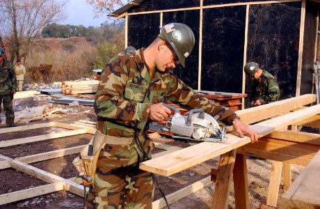 US Navy 060120-F-4462M-029 U.S. Navy Seabees assigned to Naval Mobile Construction Battalion Four (NMCB-4)) build a temporary school in the mountains near Muzaffarabad, Pakistan photo