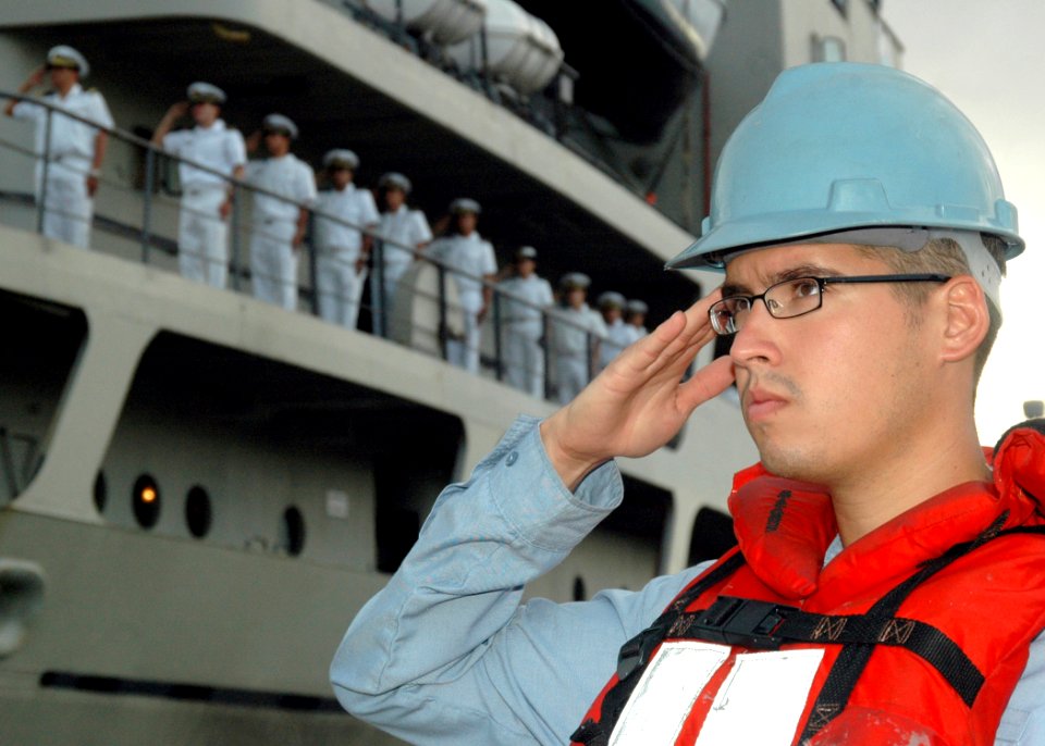 US Navy 060125-N-3019M-001 Sonar Technician 3rd Class Donnie Garrison salutes the National Ensign during morning colors before casting off the Peruvian transport ship BAP Mollendo (ATC 131)