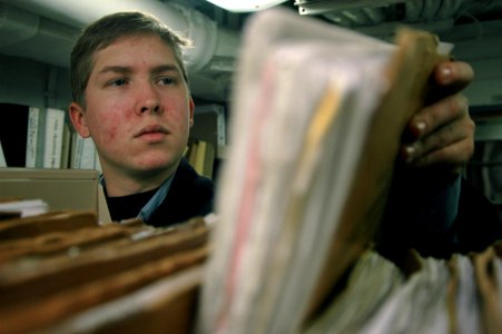 US Navy 060131-N-1332Y-016 Personnel Specialist 3rd Class Justin Webb from Slidell, La., researches service records on aboard the guided missile destroyer USS Fitzgerald (DDG 62)