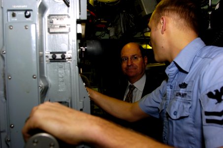 US Navy 060119-N-2568S-059 Electronics Technician 2nd Class Martin Franklin explains to Secretary of the Navy (SECNAV), the Honorable, Dr. Donald C. Winter the operation and capabilities of the periscope photo