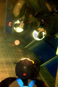 US Navy 060201-N-9500T-207 A U.S. Navy diver oversees two students attending a water survival refresher course as they begin their egress