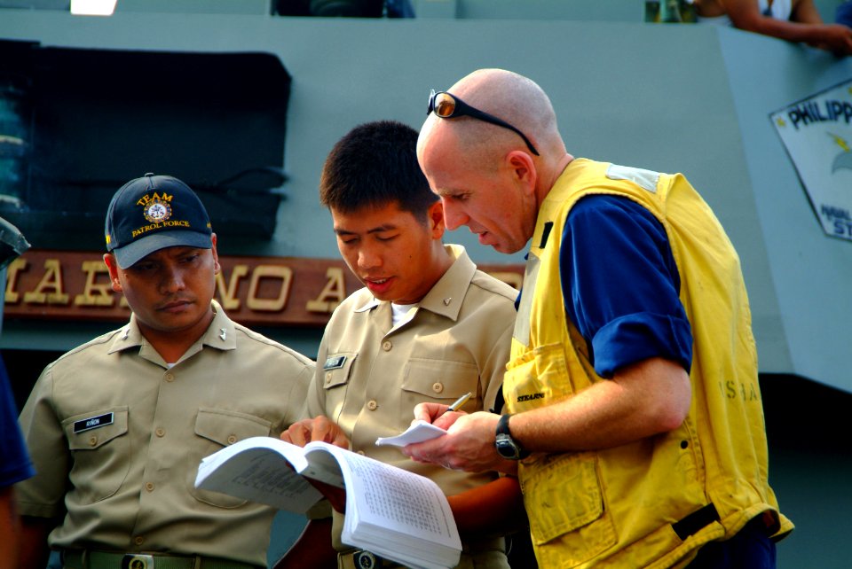 US Navy 060220-N-4772B-452 Chief Warrant Officer Marc Manor coordinates information with Philippine Naval personnel while conducting a beach survey