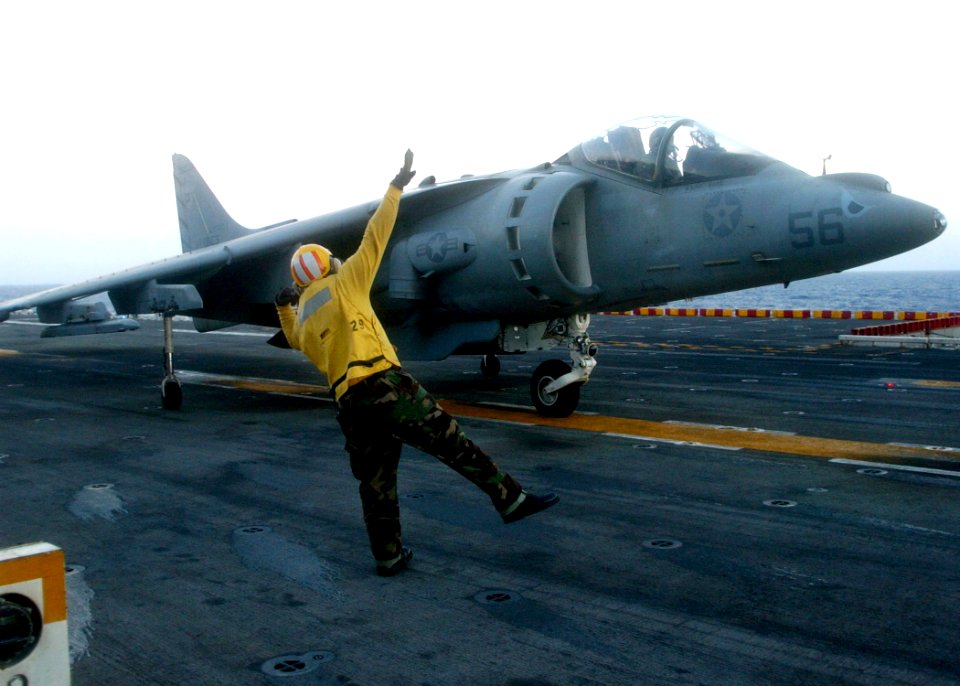 US Navy 060202-N-0716S-008 Aviation Boatswain's Mate 2nd class Jerry Lowe signals a AV-8-B Harrier to launch from the flight deck aboard the amphibious assault ship USS Tarawa (LHA 1)