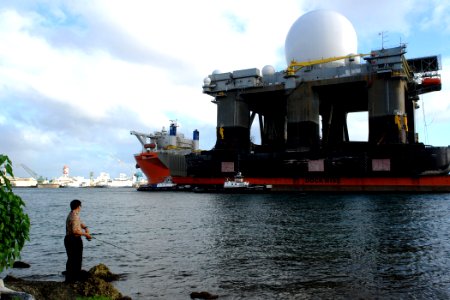 US Navy 060109-N-9643K-102 A fisherman watches as the heavy lift vessel MV Blue Marlin enters Pearl Harbor, Hawaii, with the Sea Based X-Band Radar