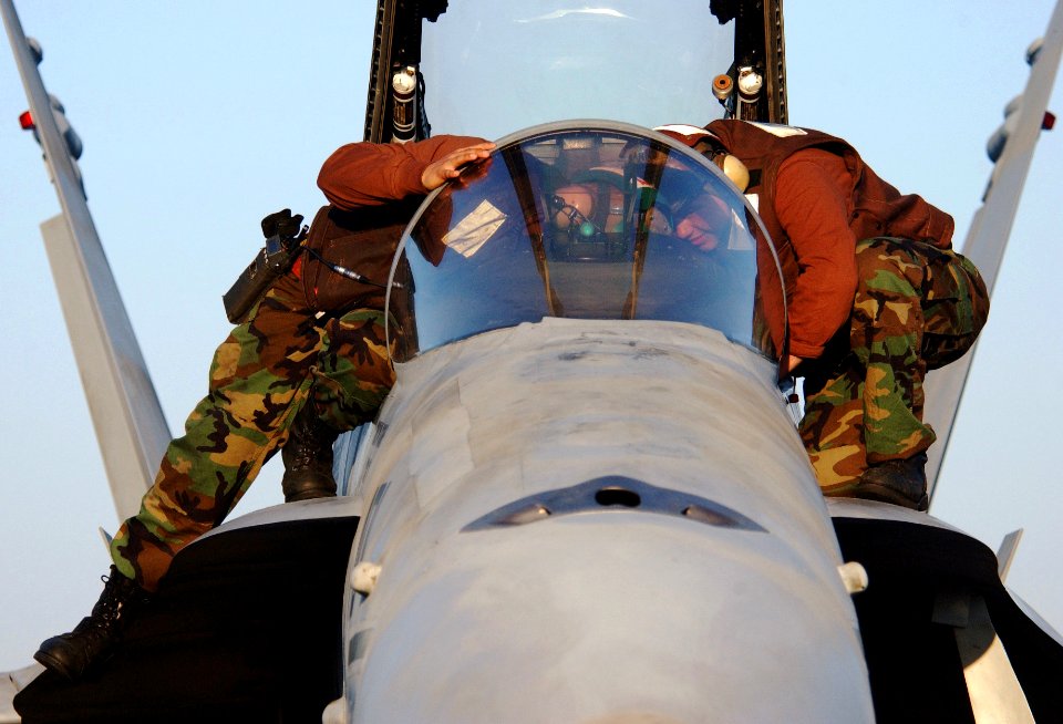 US Navy 060225-N-4776G-068 Two Sailors assigned to the Fist of the Fleet of Strike Fighter Squadron Two Five (VFA-25) conduct pre-flight checks on an F-A-18C Hornet before flight operations