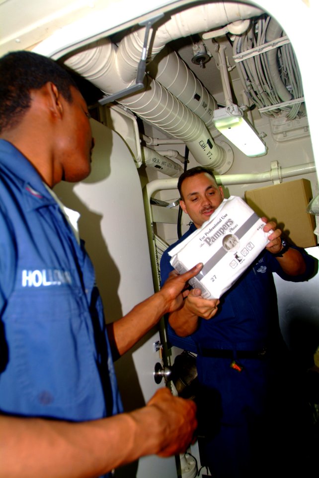US Navy 060218-N-4772B-024 Hospital Corpsman 2nd Class Leonard H. Ray, right, and Hospital Corpsman 3rd Class John K. Holloman inventory diapers and other relief supplies aboard the dock landing ship USS Harpers Ferry (LSD 49)