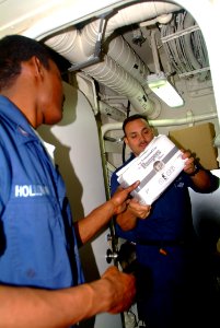 US Navy 060218-N-4772B-024 Hospital Corpsman 2nd Class Leonard H. Ray, right, and Hospital Corpsman 3rd Class John K. Holloman inventory diapers and other relief supplies aboard the dock landing ship USS Harpers Ferry (LSD 49)