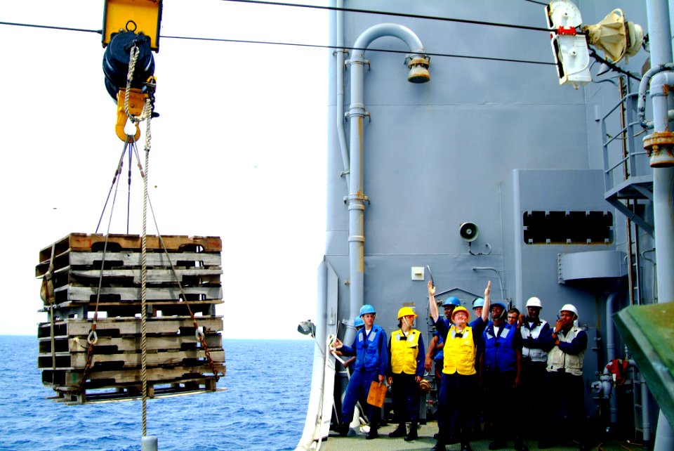 US Navy 060302-N-4772B-095 Sailors gives hand signals to move pallets from the Military Sealift Command (MSC) underway replenishment oilier USNS Yukon (T-AO 202)