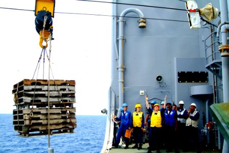US Navy 060302-N-4772B-095 Sailors gives hand signals to move pallets from the Military Sealift Command (MSC) underway replenishment oilier USNS Yukon (T-AO 202)