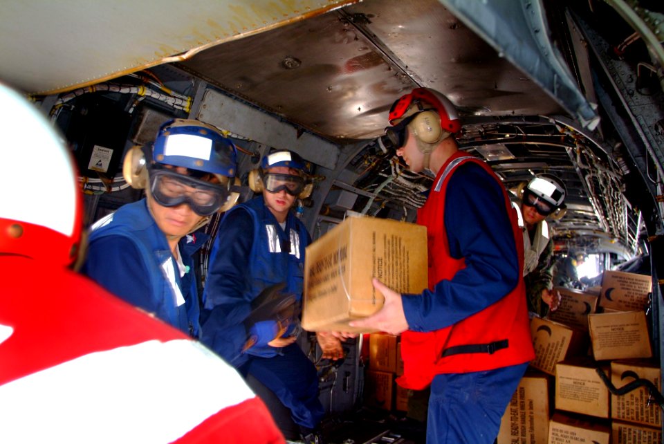 US Navy 060219-N-4772B-030 Aboard the dock landing ship USS Harpers Ferry (LSD 49) Sailors and Marines load relief supplies aboard a CH-46E Sea Knight