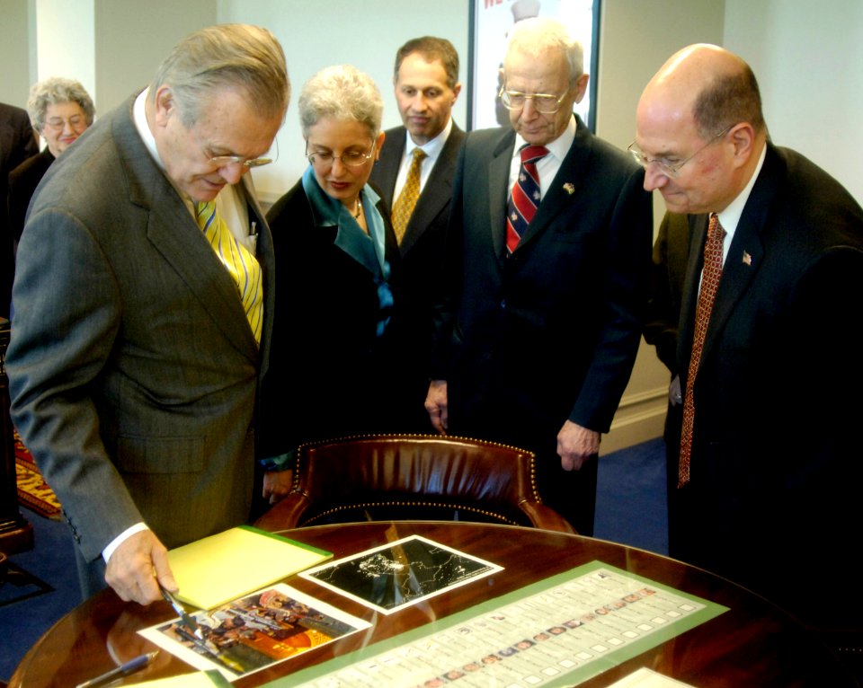 US Navy 060221-N-0696M-016 Secretary of Defense (SECDEF), the Honorable Donald H. Rumsfeld, left, and Secretary of the Navy (SECNAV), the Honorable Dr. Donald C. Winter, right, look at several artifacts in Rumsfeld's offi