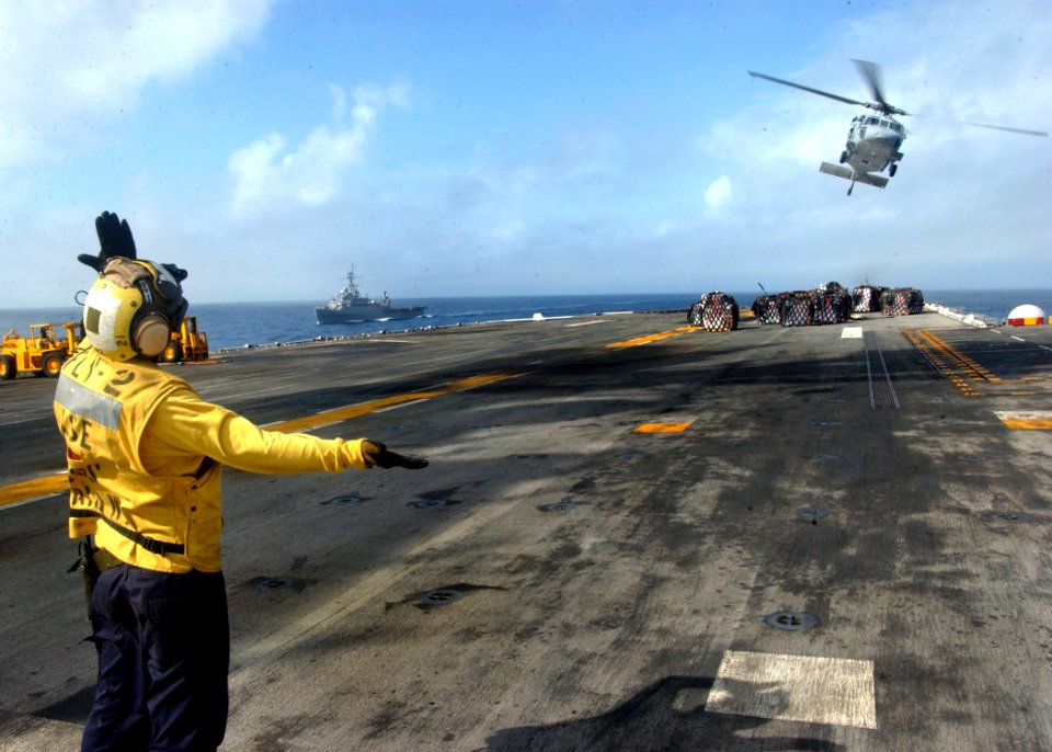US Navy 060203-N-0716S-006 Aviation Boatswain's Mate Airman Jonathan Sandoval directs a SH-60 Seahawk Helicopter as it takes-off from the amphibious assault ship USS Tarawa (LHA 1) during a vertical replenishment (VERTREP