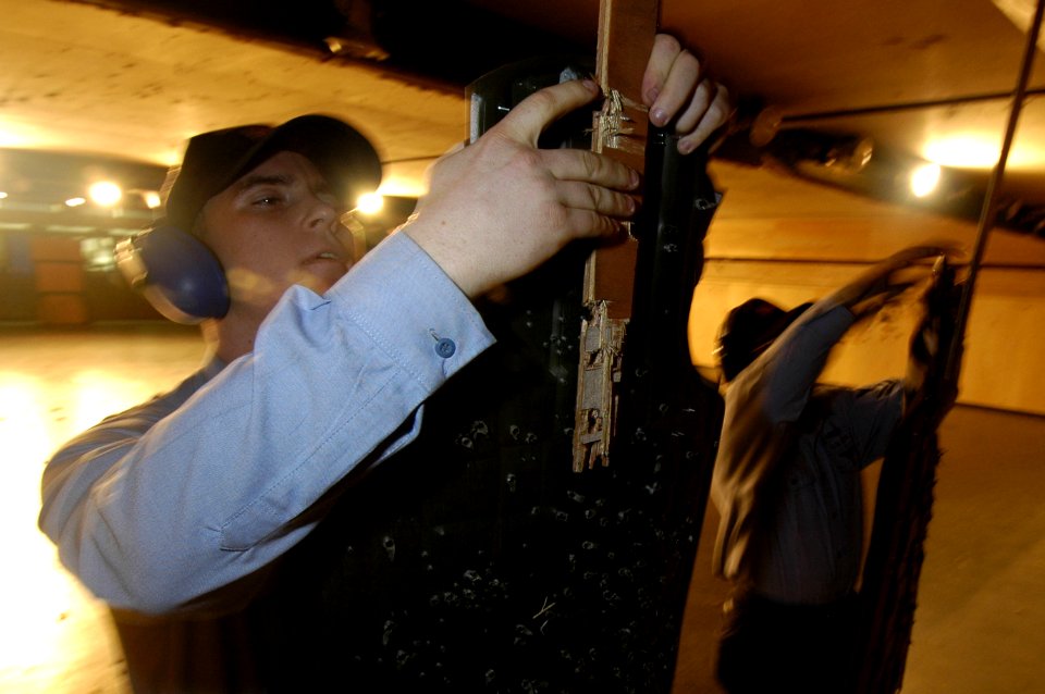 US Navy 060317-N-9389D-085 Aviation Ordnanceman Jereme Davis hangs a replacement target in the Commander, Fleet Activities Yokosuka (CFAY) gun range during a weapon qualification session