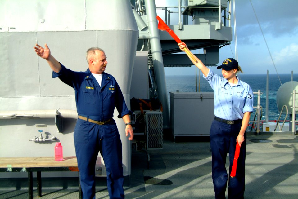 US Navy 060225-N-4772B-049 Chief Quartermaster James Clayton gives semiphore training to Quartermaster 3rd Class Kearah Critchfield on the signal bridge