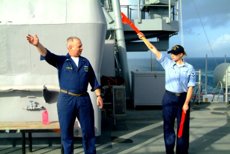 US Navy 060225-N-4772B-049 Chief Quartermaster James Clayton gives semiphore training to Quartermaster 3rd Class Kearah Critchfield on the signal bridge