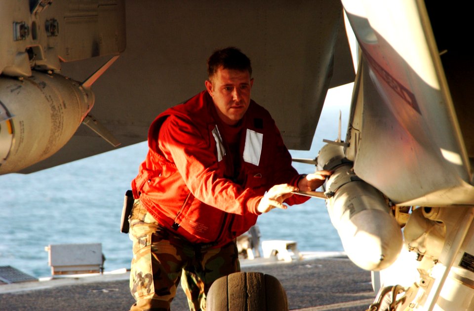 US Navy 060225-N-4776G-108 Aviation Ordnancemen 1st Class Clinton Donham check to ensure the ordnance is attached properly on an F-A-18E Super Hornet on the flight deck aboard the Nimitz-class aircraft carrier USS Ronald Reagan
