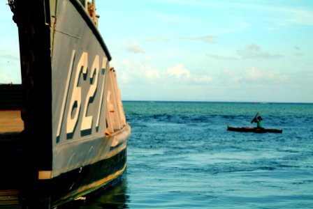 US Navy 060222-N-4772B-189 A local fisherman paddles his boat near Landing Craft Utility (LCU) 1627, beached on the small fishing village of Himbangen to drop off relief equipment photo
